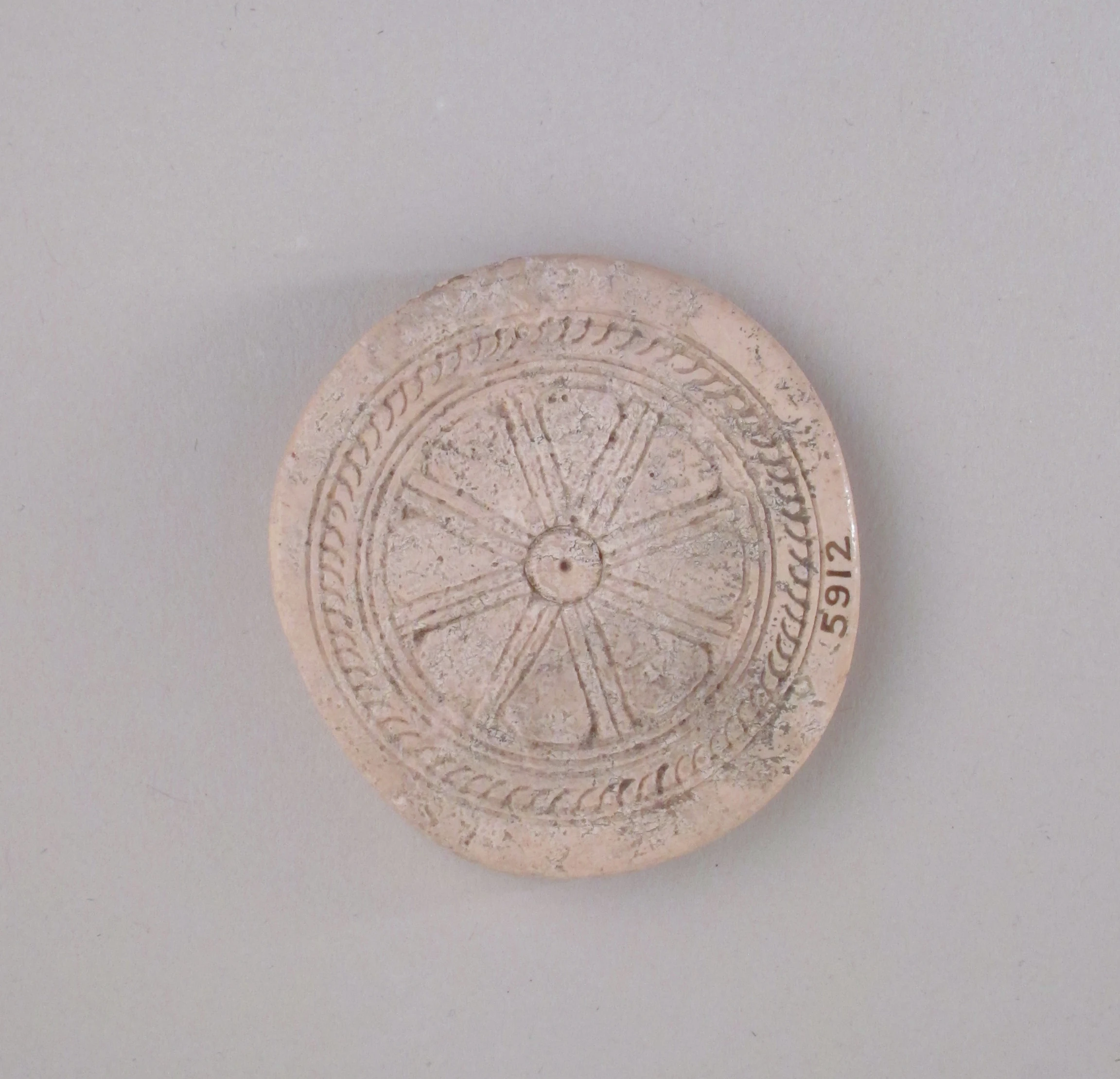 Ivory disk of a pyxis with rosette